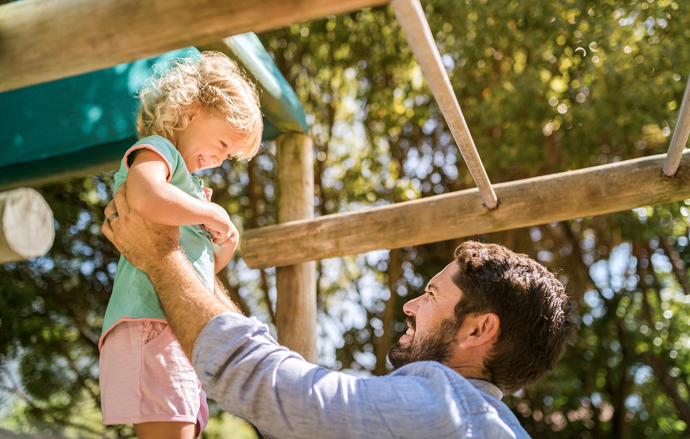 Vater mit Kind auf Spielplatz.